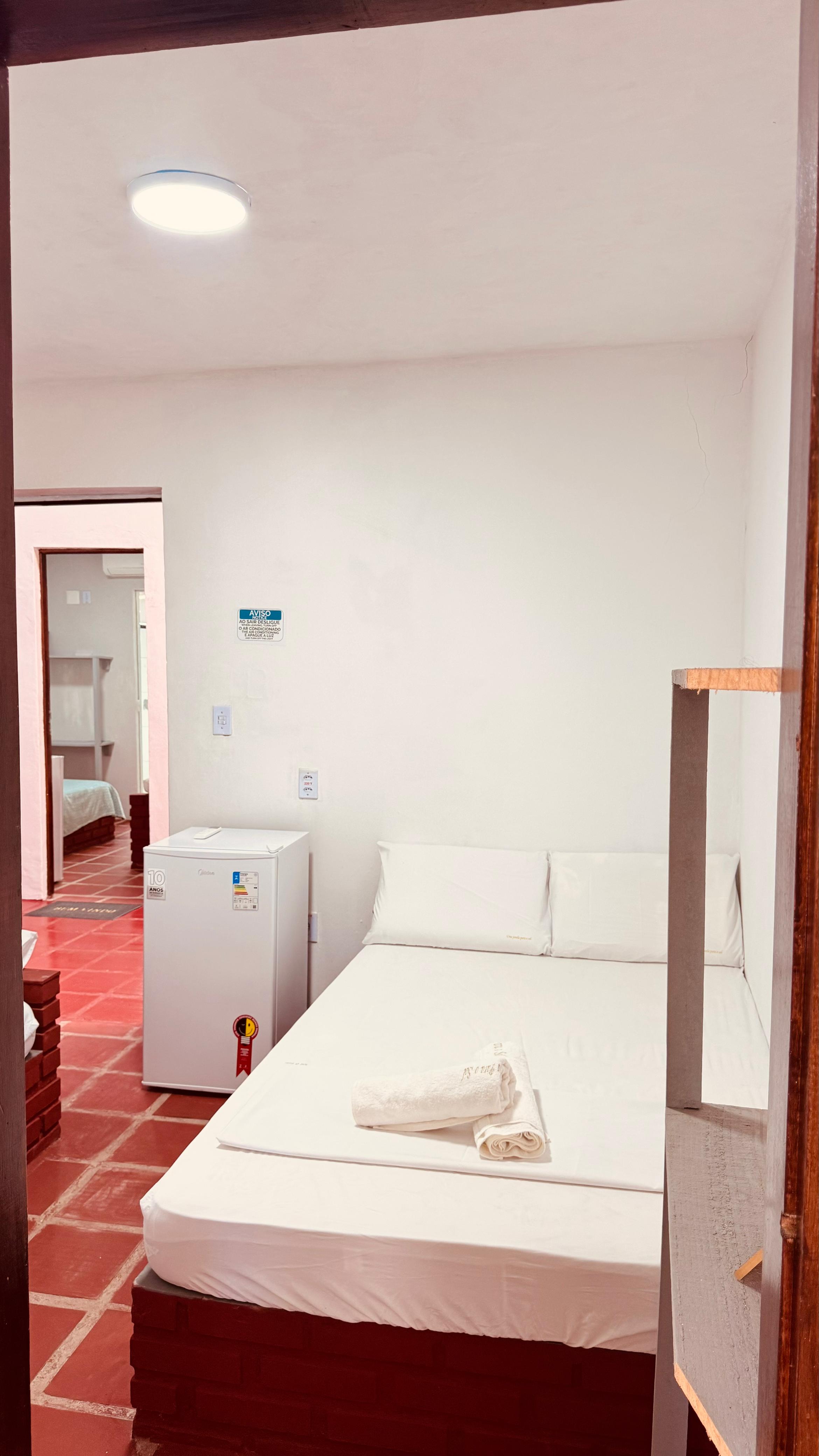Quarto de casal com frigobar e enxoval branco